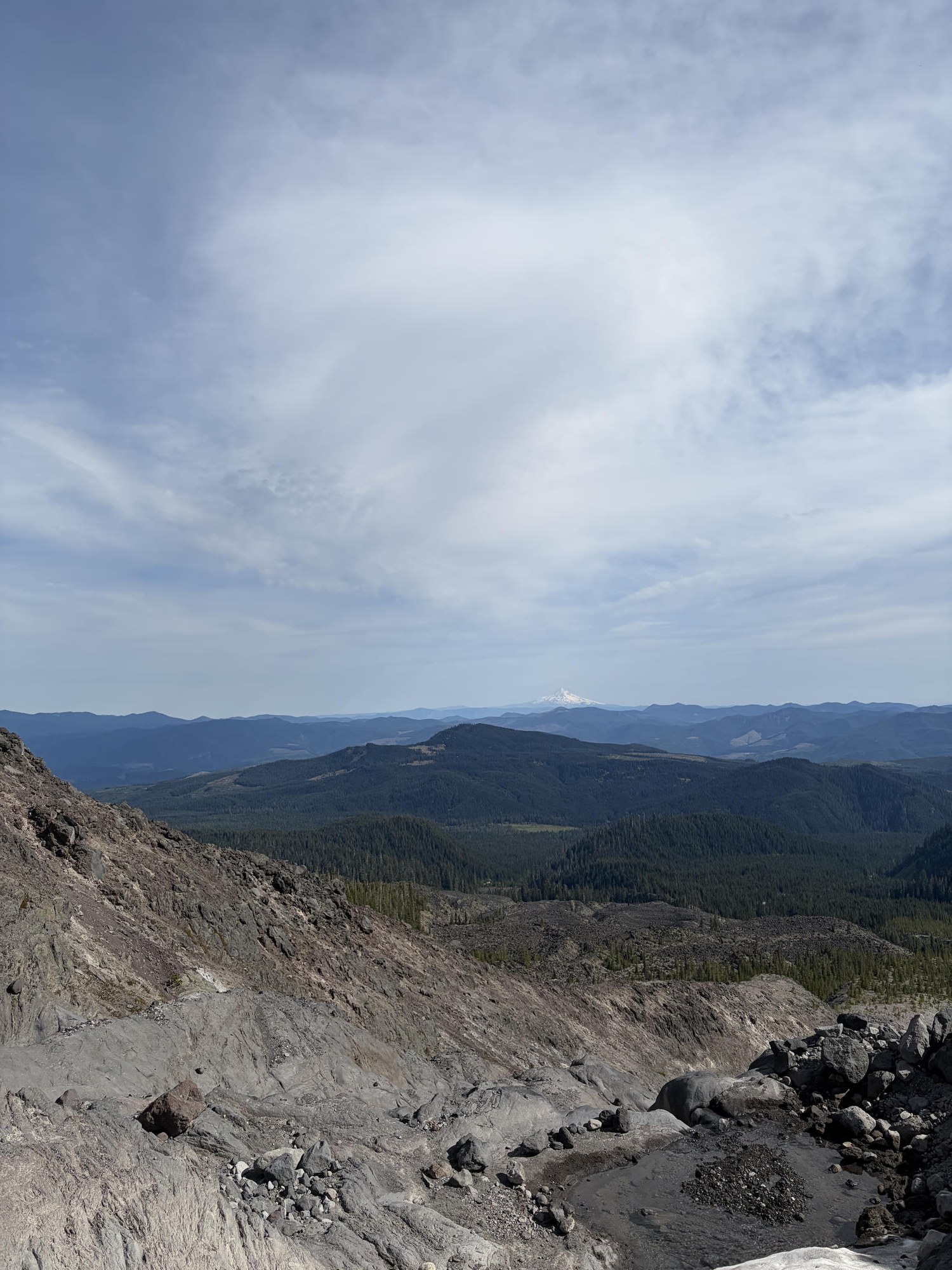 Looking south from the ashy summit slopes toward Mount Hood on the horizon