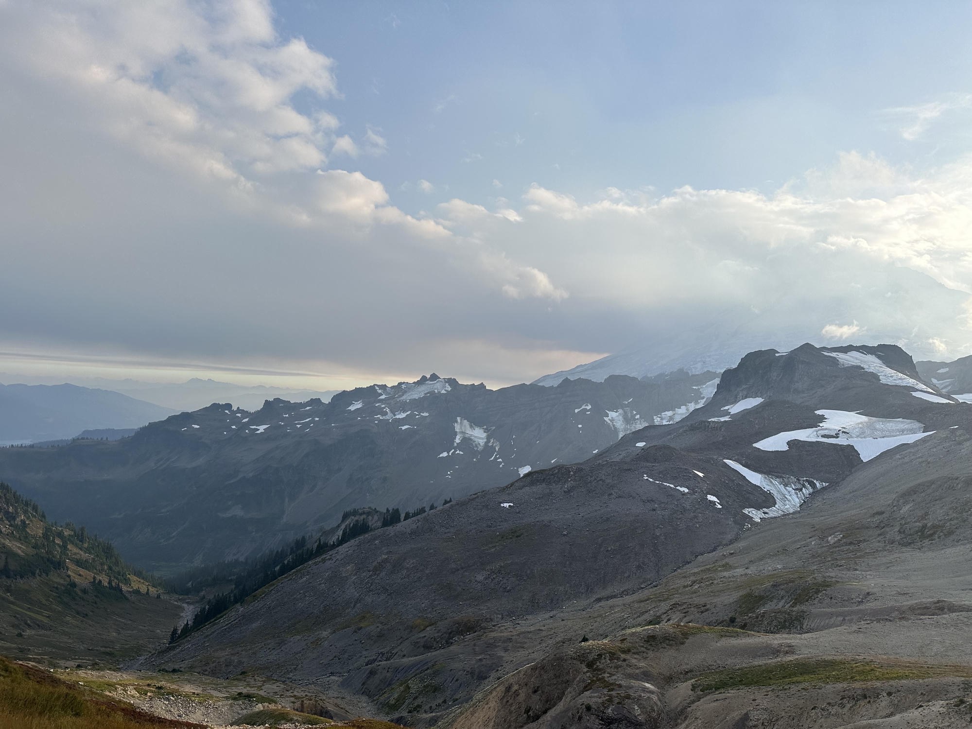 Broad snow-and-rock basin below Mount Baker's cloud-draped summit from Ptarmigan Ridge